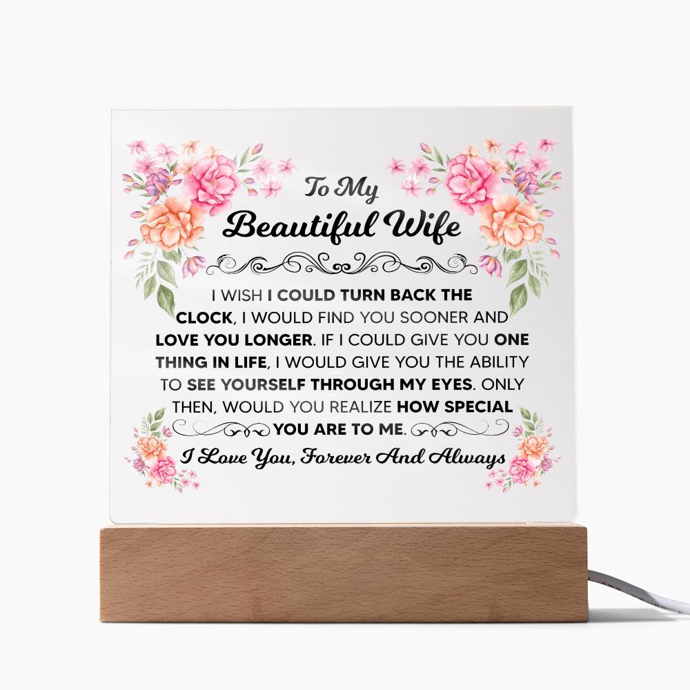 Floral LED acrylic plaque glowing on a wooden base with a romantic message from husband to wife.